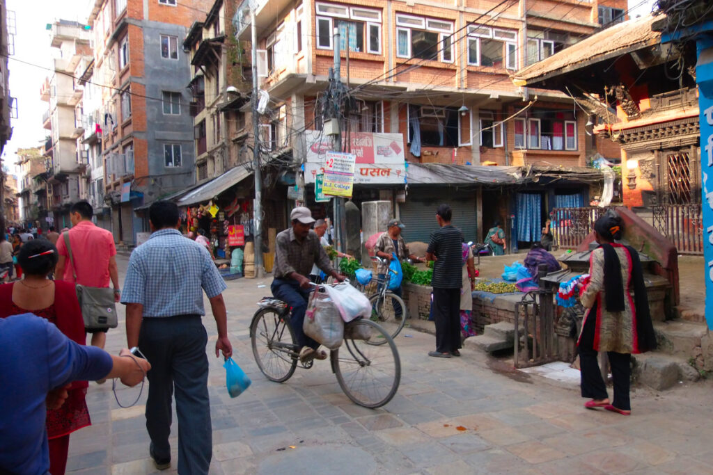 Straßenhändler und Passanten in einer Gasse der Altstadt von Kathmandu