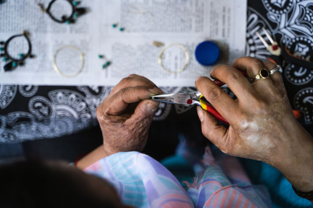 Zwei Frauen fertigen gemeinsam handgearbeiteten Schmuck in der Werkstatt von Astitwa in Nepal.