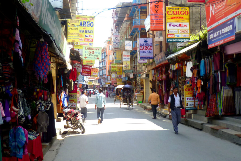 Geschäfte mit Kleidung und Souvenirs entlang einer Straße in Thamel, Kathmandu