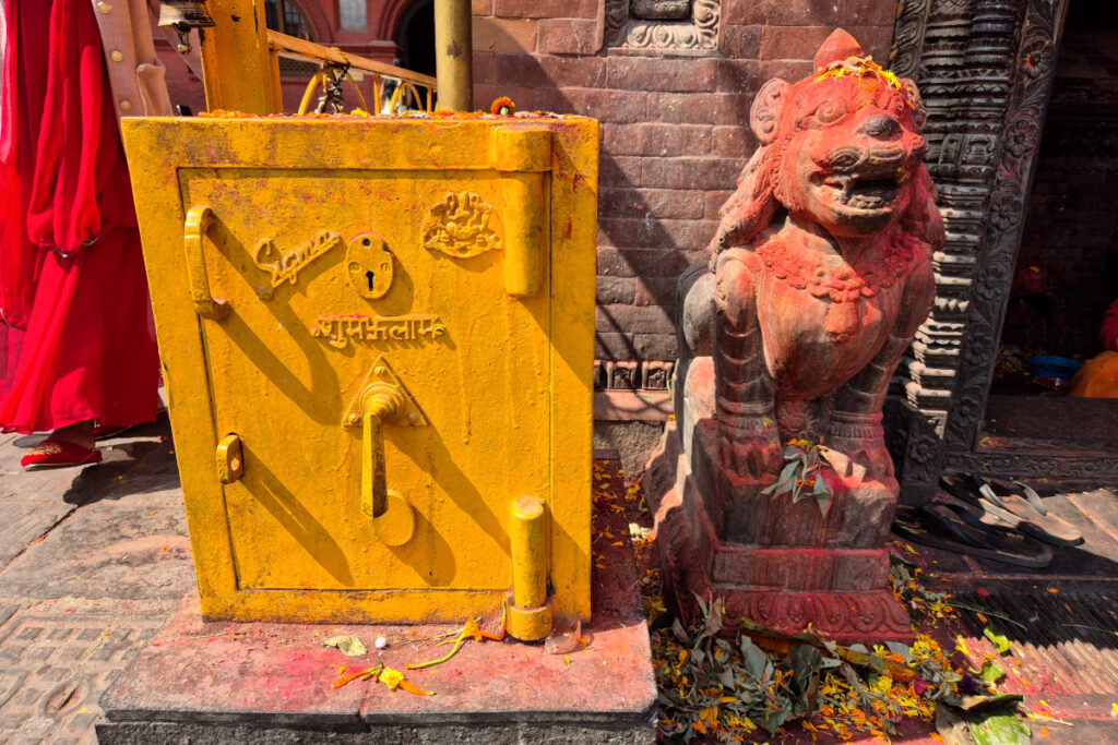 Farbenfrohe Details mit Tika und Löwenfigur im Budhanilkantha-Tempel