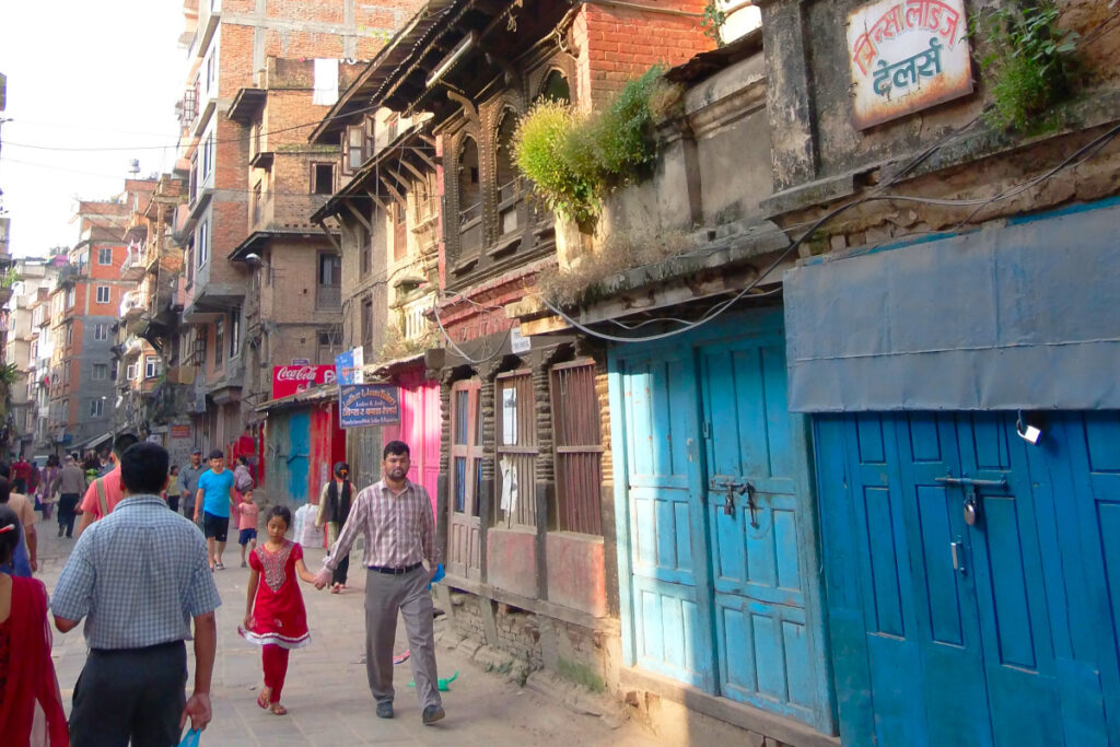 Belebte Gasse mit traditionellen Häusern in der Altstadt von Kathmandu