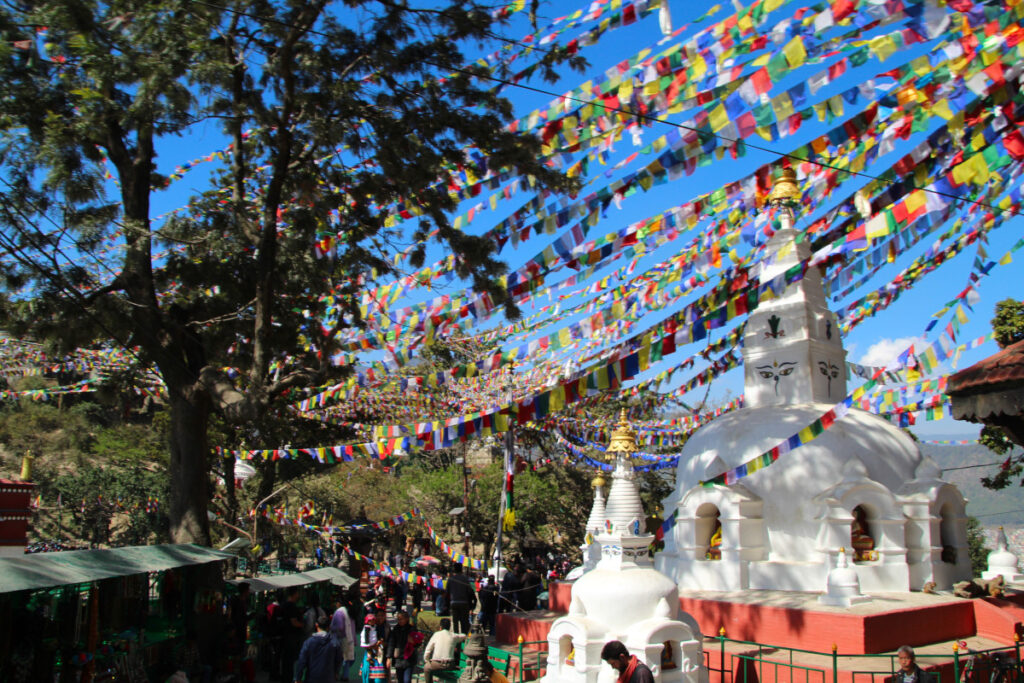 Kleiner Stupa und Gebetsfahnen auf dem weitläufigen Gelände von Swayambhunath in Kathmandu