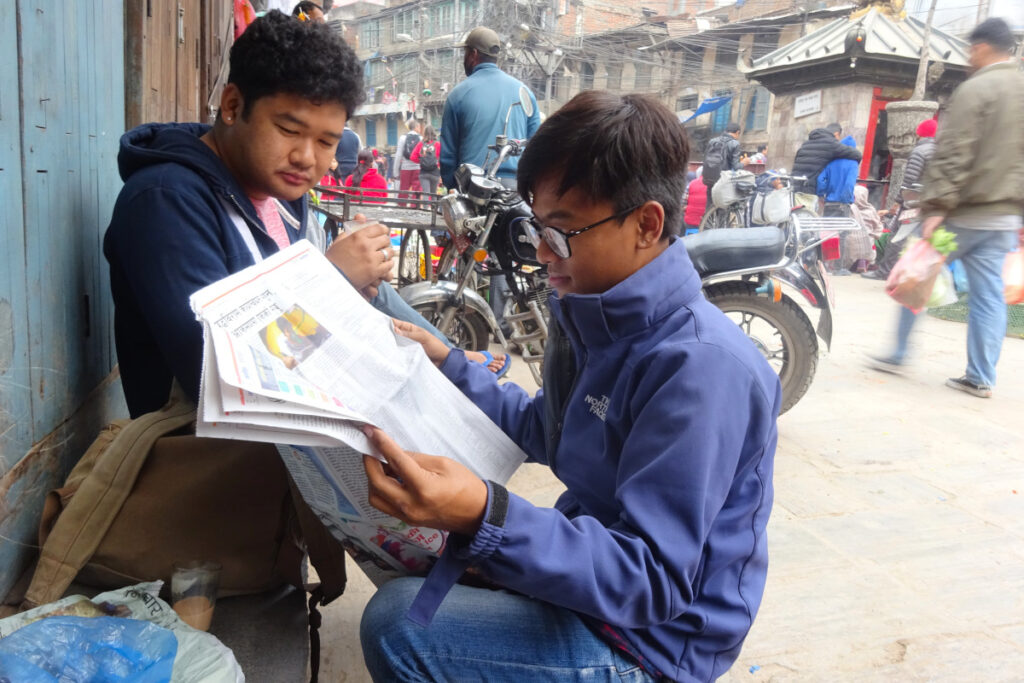 Rajeev und Vishal sitzen bei einer Teepause am Straßenrand in Kathmandus Altstadt