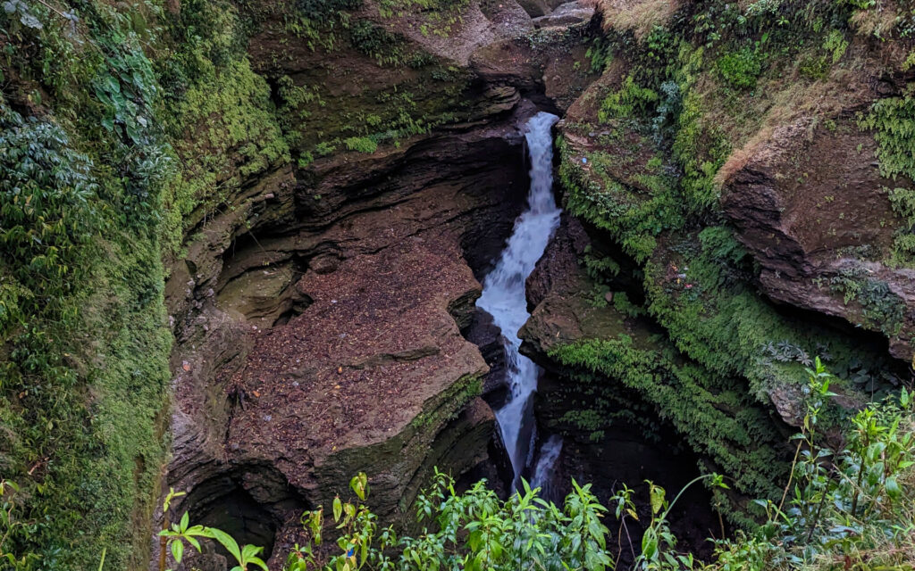 Devi’s Falls in Pokhara Devi’s Falls in Pokhara, wo das Wasser zwischen steilen, bewachsenen Felswänden in eine tiefe Schlucht stürzt.