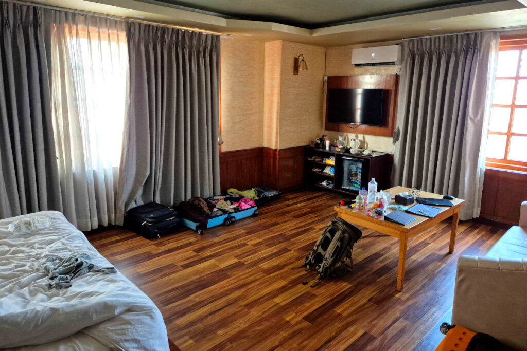 Unser Zimmer im Hotel Nova Nook in Kathmandu Zimmer im Hotel Nova Nook in Kathmandu mit Holzboden, Bett und Reisegepäck