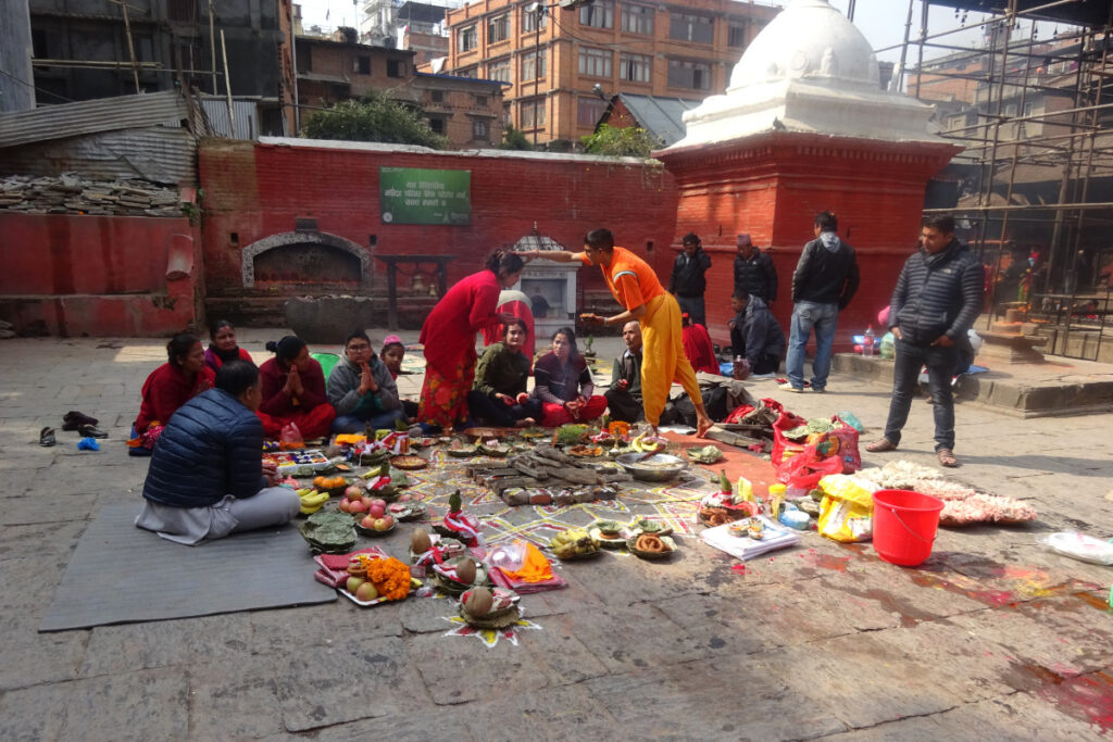 Feuerritual am Bangalamukhi-Tempel in Patan Gläubige und ein Priester bei einem hinduistischen Feuerritual mit Opfergaben am Bangalamukhi-Tempel in Patan
