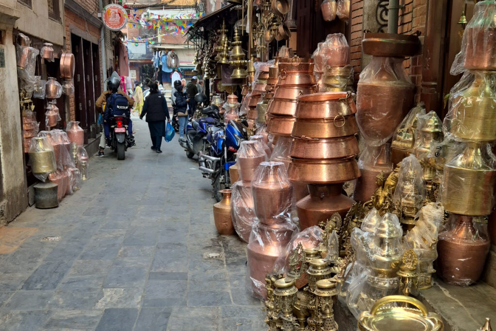 Metallhandwerk in der Altstadt von Patan Enge Gasse in Patan mit Geschäften für Kupfer- und Messingwaren, religiösen Figuren und traditionellem Metallhandwerk